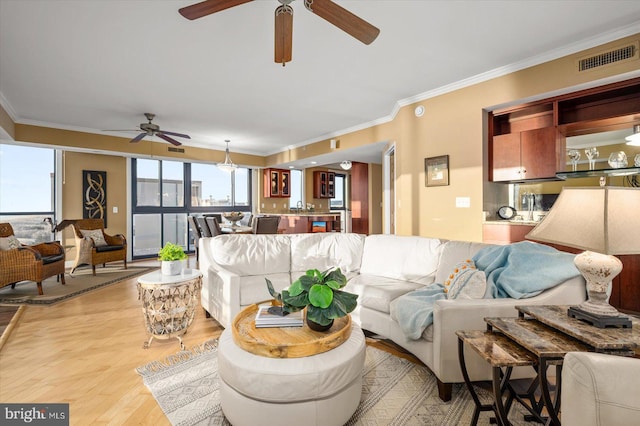 living room featuring ornamental molding and light wood-type flooring