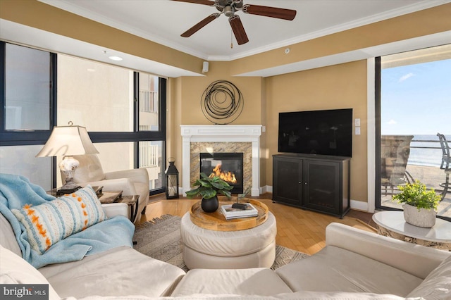 living room with a fireplace, ornamental molding, light hardwood / wood-style floors, and ceiling fan