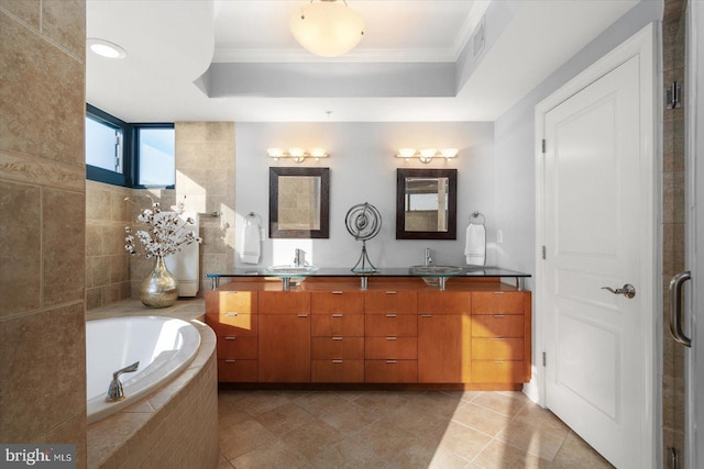 bathroom with tiled tub, vanity, and crown molding