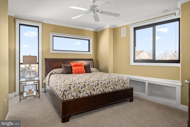 carpeted bedroom featuring crown molding and ceiling fan