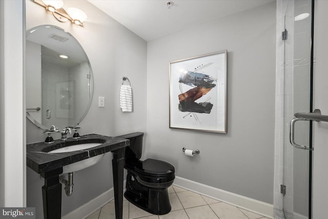 bathroom with an enclosed shower, sink, tile patterned floors, and toilet