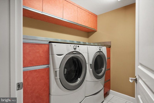 laundry room featuring cabinets, washing machine and dryer, and light tile patterned floors