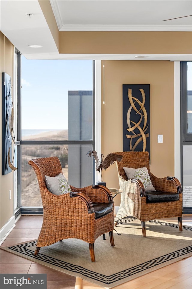 sitting room with crown molding, plenty of natural light, and hardwood / wood-style floors