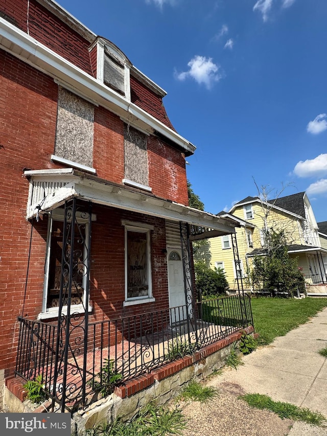 view of front of property featuring brick siding and fence