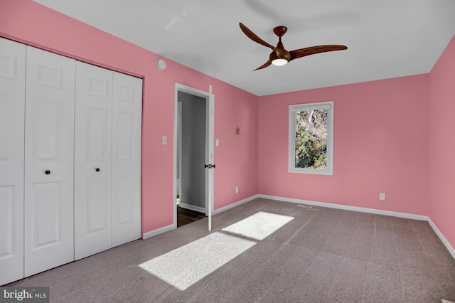 unfurnished bedroom featuring carpet, ceiling fan, and a closet