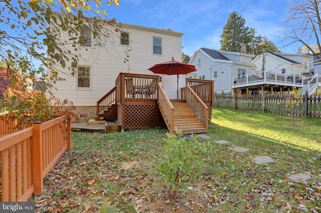 rear view of house featuring a yard and a wooden deck