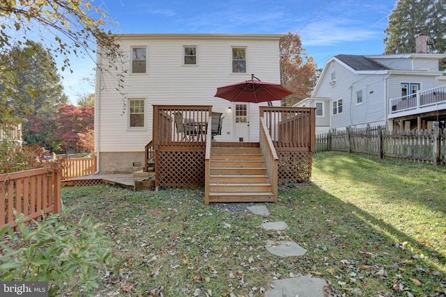 back of house featuring a yard and a wooden deck