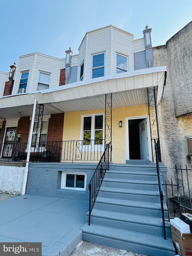 view of property featuring covered porch and stucco siding