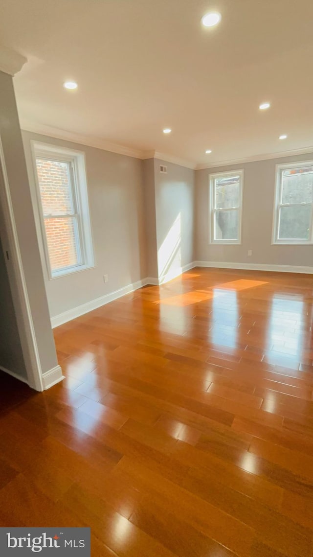 unfurnished room with crown molding and hardwood / wood-style flooring