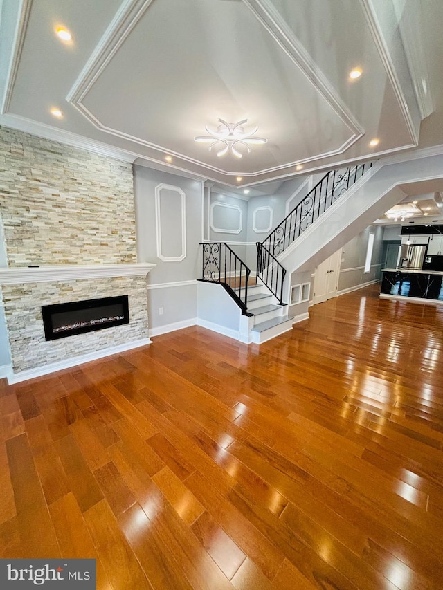 unfurnished living room with crown molding, hardwood / wood-style floors, and a fireplace