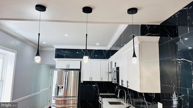 kitchen featuring white cabinets, crown molding, decorative light fixtures, appliances with stainless steel finishes, and tasteful backsplash