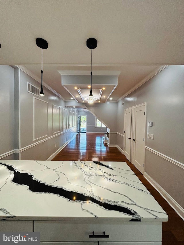 kitchen featuring light stone countertops, dark hardwood / wood-style flooring, and crown molding