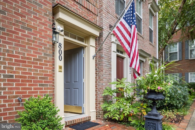 doorway to property with brick siding