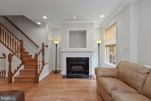 living area featuring stairs, a fireplace, wood finished floors, and recessed lighting