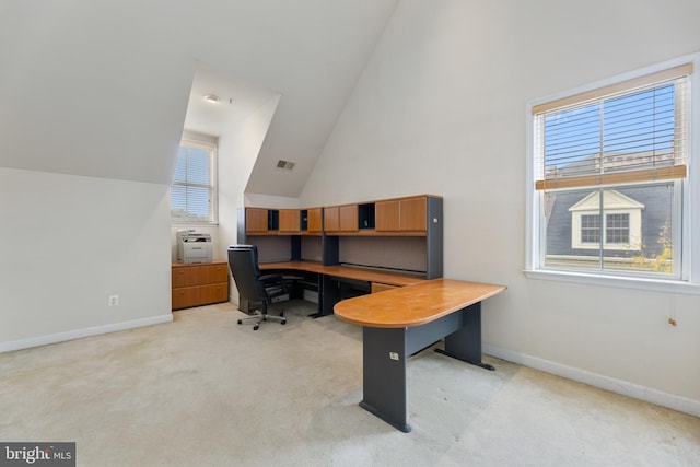 home office with high vaulted ceiling, light colored carpet, visible vents, and baseboards