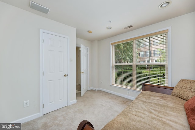 living area with carpet, visible vents, and baseboards