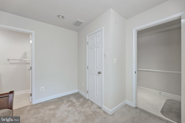 unfurnished bedroom featuring carpet, baseboards, a closet, and tile patterned floors