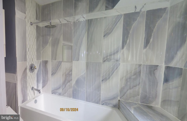 bathroom featuring tiled shower / bath combo and tile walls