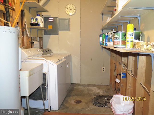 washroom featuring washing machine and clothes dryer, electric panel, and water heater