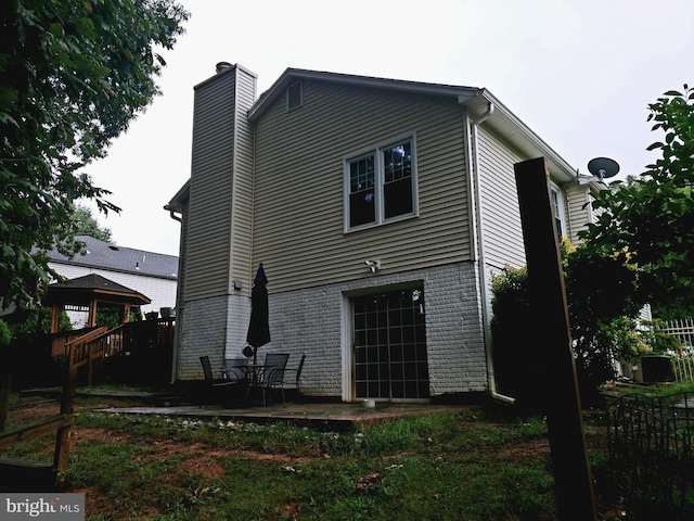 back of property featuring a gazebo