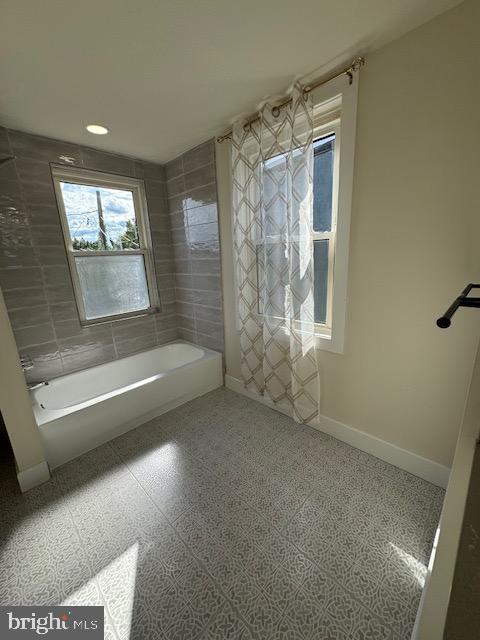 bathroom with a tub to relax in, recessed lighting, tile patterned floors, and baseboards