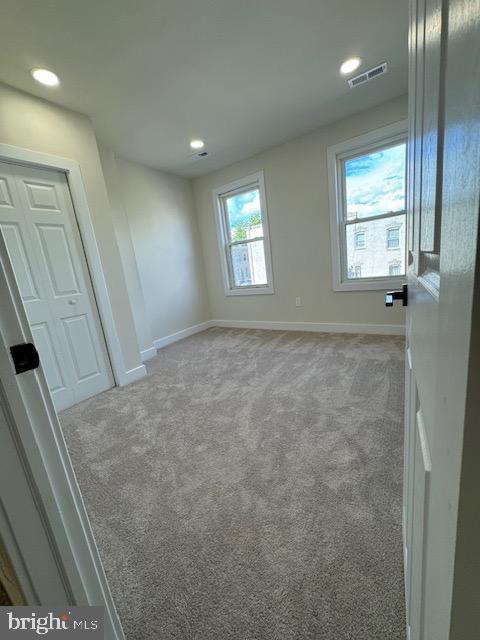 interior space featuring recessed lighting, baseboards, visible vents, and light colored carpet