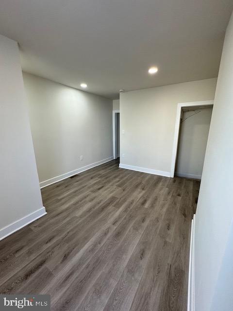 unfurnished bedroom with recessed lighting, dark wood finished floors, and baseboards