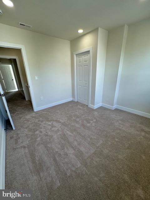 unfurnished bedroom featuring baseboards, visible vents, carpet flooring, and recessed lighting