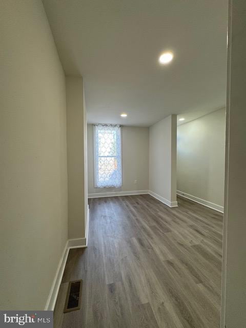 spare room with baseboards, visible vents, wood finished floors, and recessed lighting