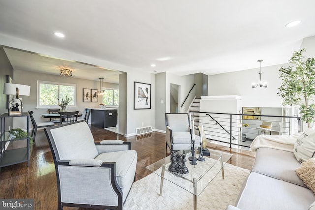 living room featuring dark wood-type flooring and an inviting chandelier