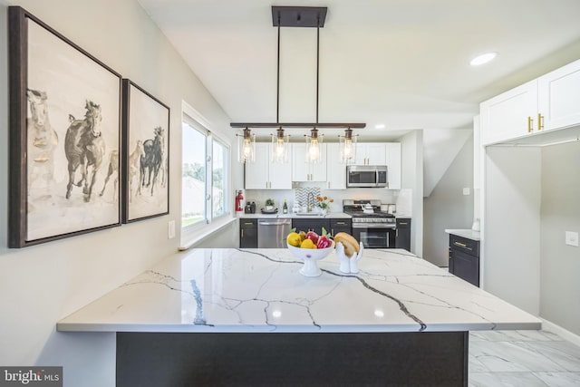 kitchen featuring hanging light fixtures, kitchen peninsula, stainless steel appliances, and white cabinetry