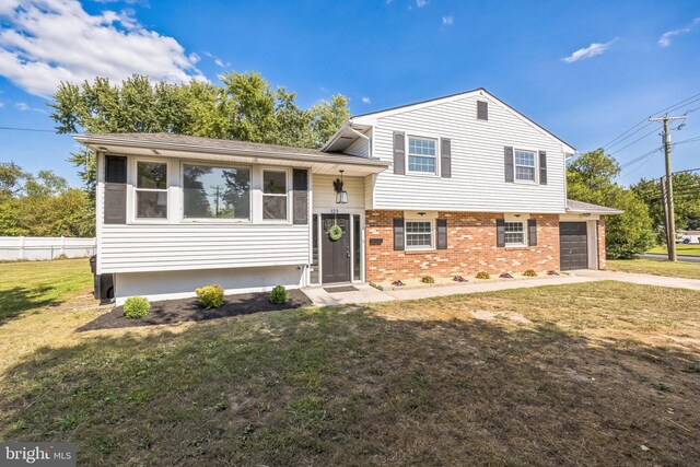 tri-level home with a front lawn and a garage