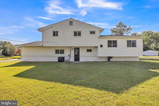 back of house with a lawn and central air condition unit