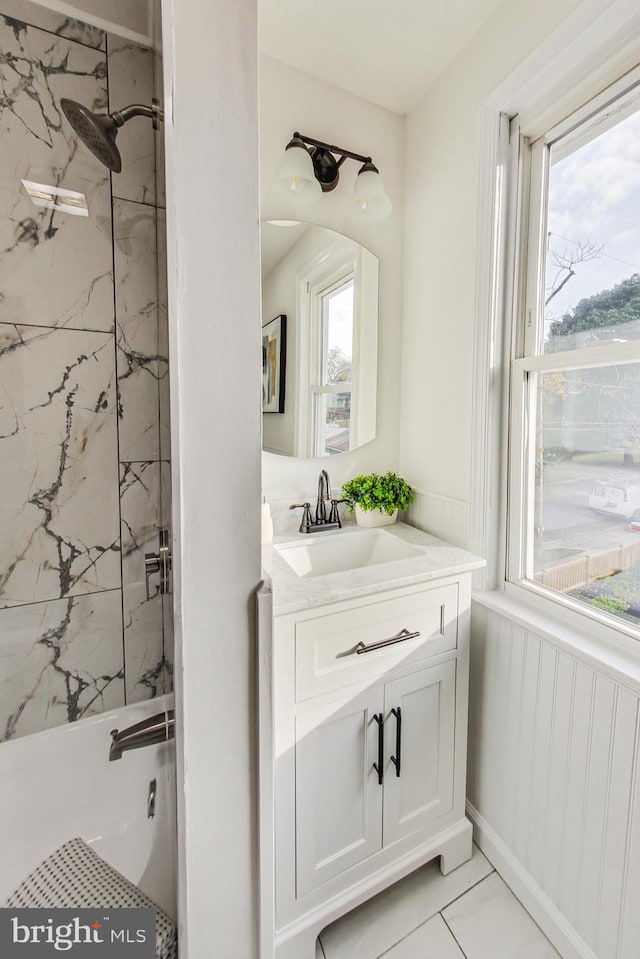 bathroom with vanity, tiled shower / bath combo, and tile patterned flooring