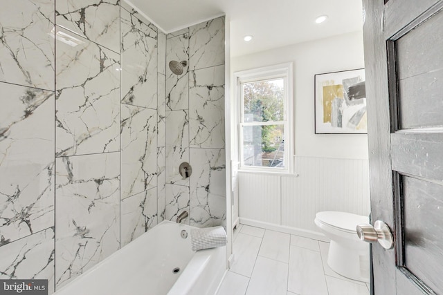 bathroom with tiled shower / bath combo, toilet, and tile patterned flooring