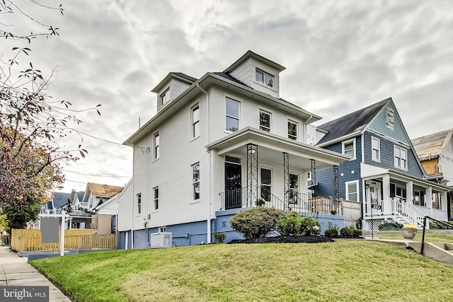 view of front of house with a front yard, ac unit, and a porch