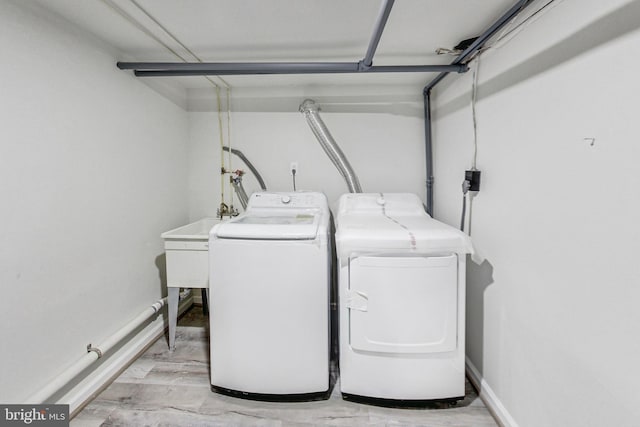 laundry area with washer and dryer and light wood-type flooring