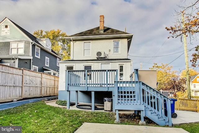 rear view of property featuring a wooden deck, a yard, and ac unit