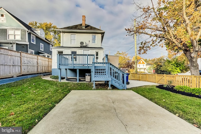 back of property with a patio, a deck, and a lawn