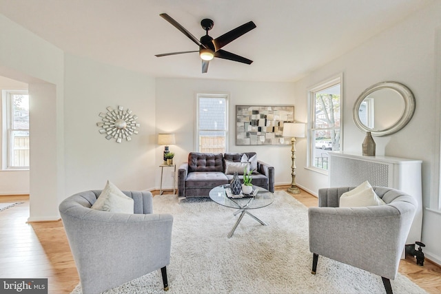 living room with light wood-type flooring and ceiling fan