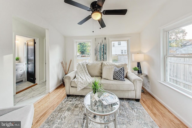 living room featuring a wealth of natural light, wood-type flooring, and ceiling fan