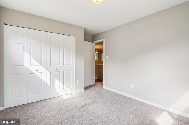 unfurnished bedroom featuring a closet and light carpet