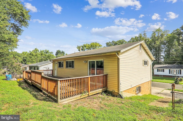 back of property with a lawn and a deck