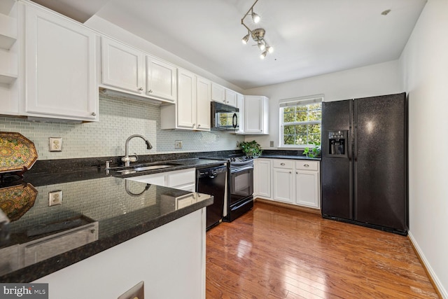 kitchen featuring white cabinets, hardwood / wood-style flooring, sink, black appliances, and rail lighting