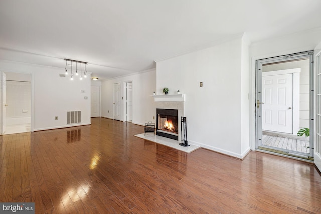 unfurnished living room with hardwood / wood-style floors and ornamental molding