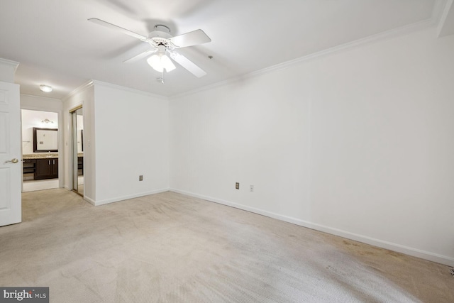 carpeted spare room with ceiling fan and ornamental molding