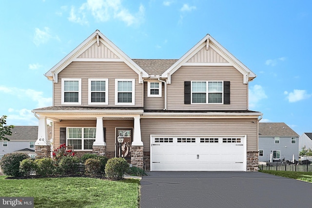 craftsman inspired home with a garage, a porch, and a front yard