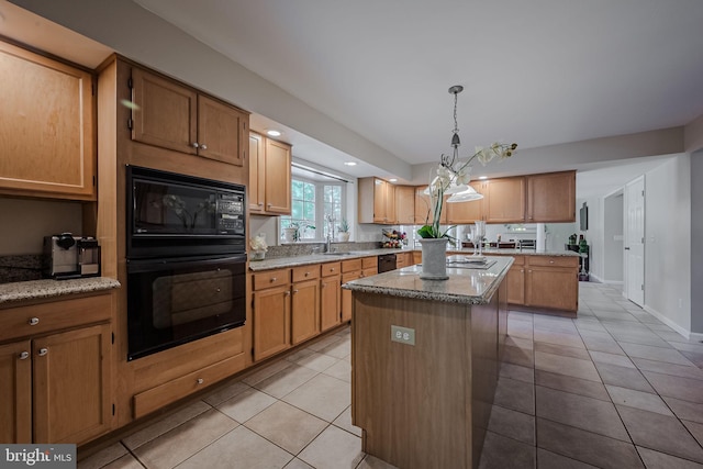 kitchen with a kitchen island, black appliances, sink, pendant lighting, and light tile patterned floors