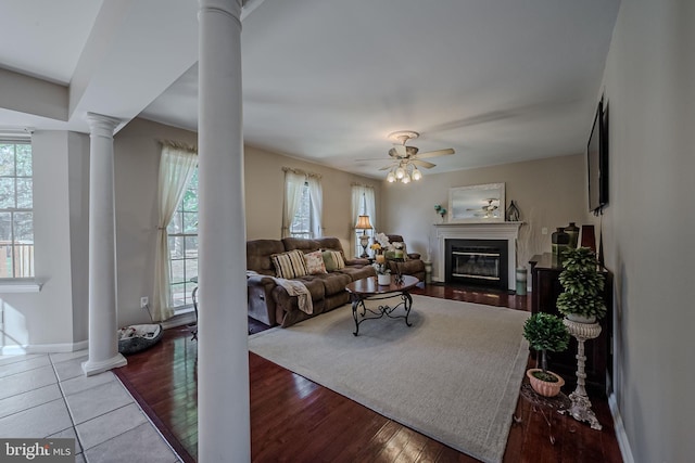 living room with ornate columns, light hardwood / wood-style flooring, and ceiling fan