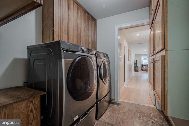 clothes washing area with independent washer and dryer and light hardwood / wood-style floors